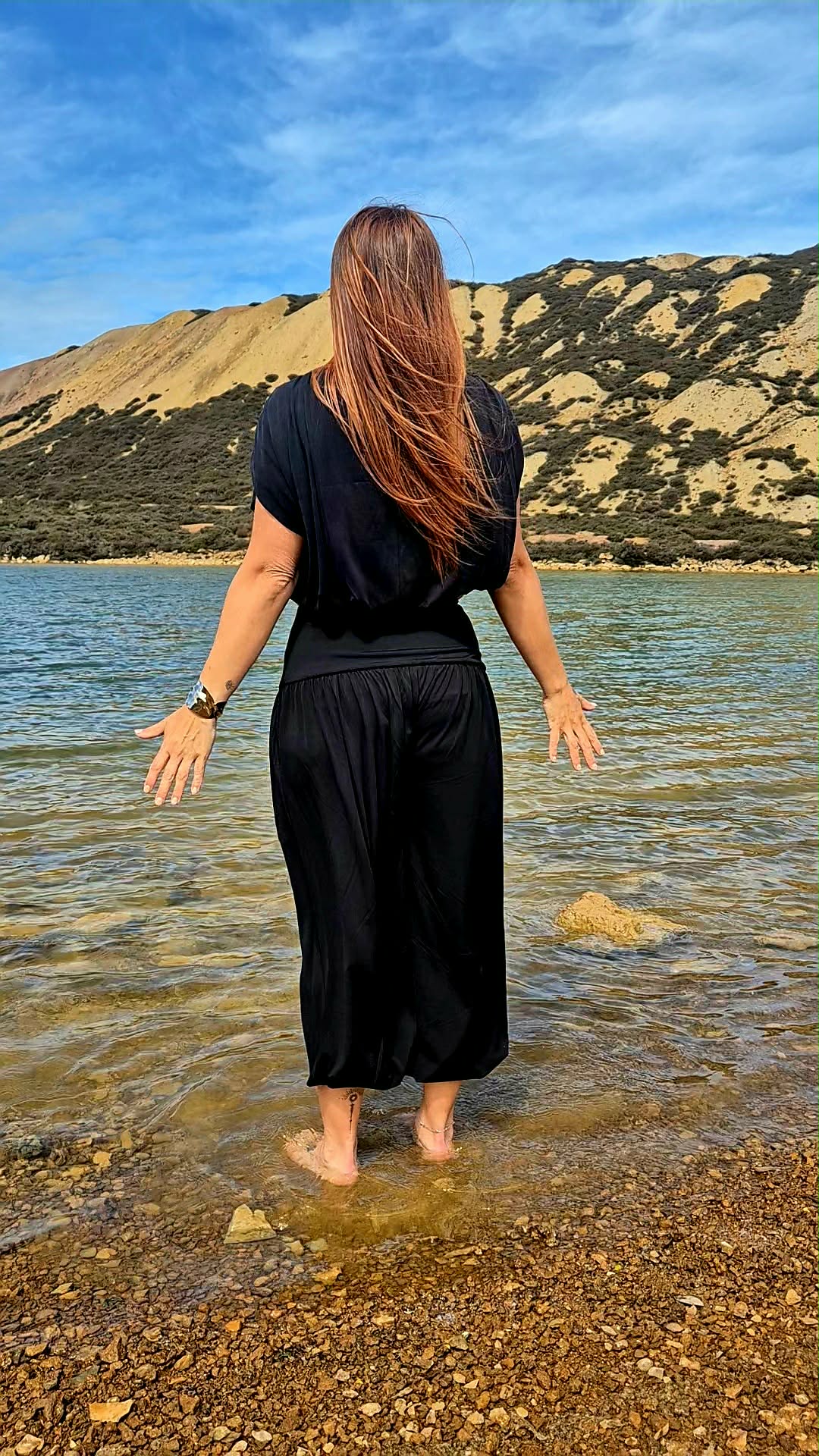 Tilly standing in water with mountains behind her